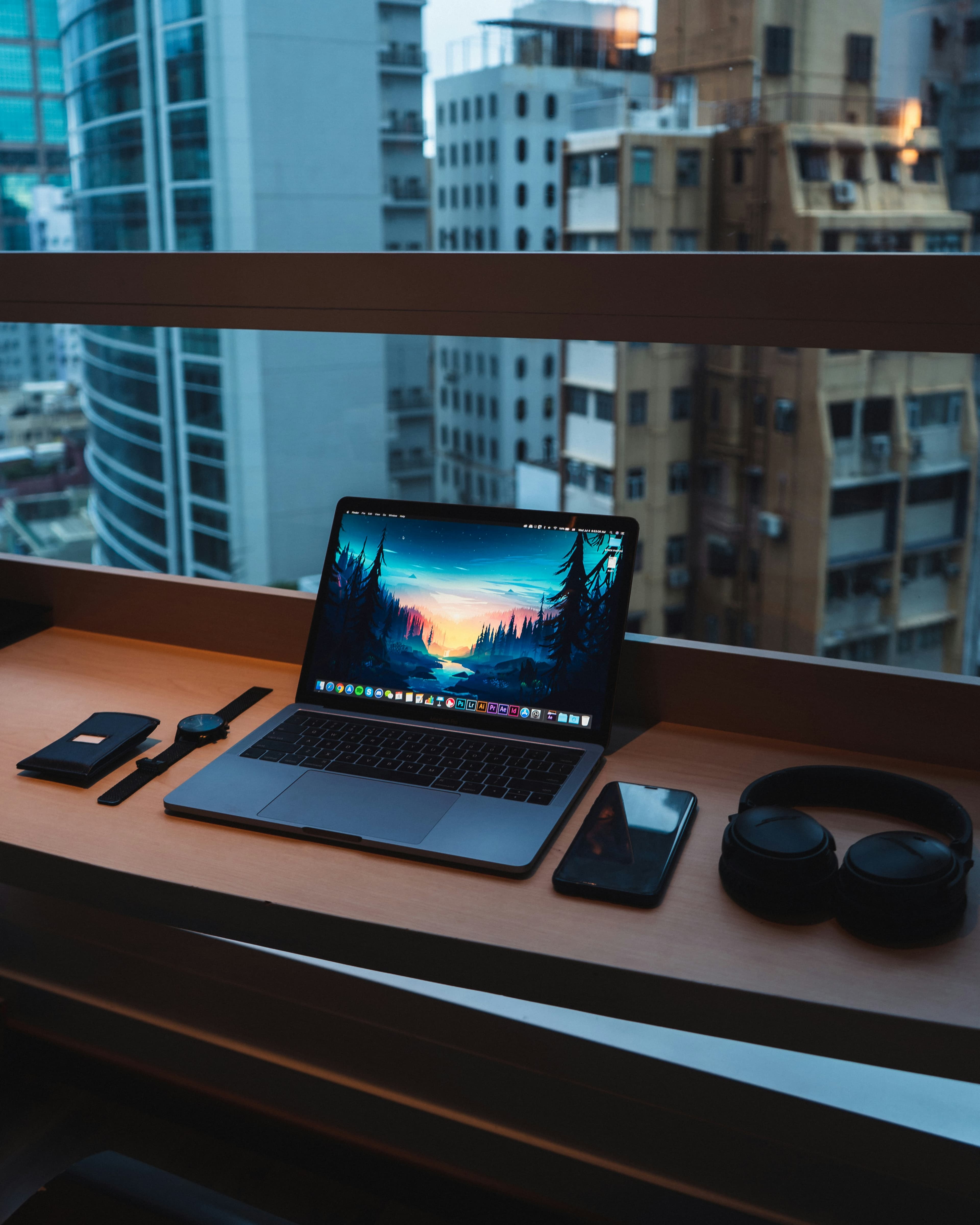 Premium tech workspace with laptop, headphones, and accessories